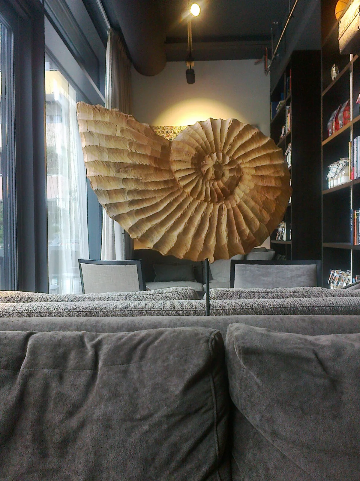 Große Holzskulptur in Form einer spiralförmigen, fossilen Schnecke im Hotel Soulmade in Garching